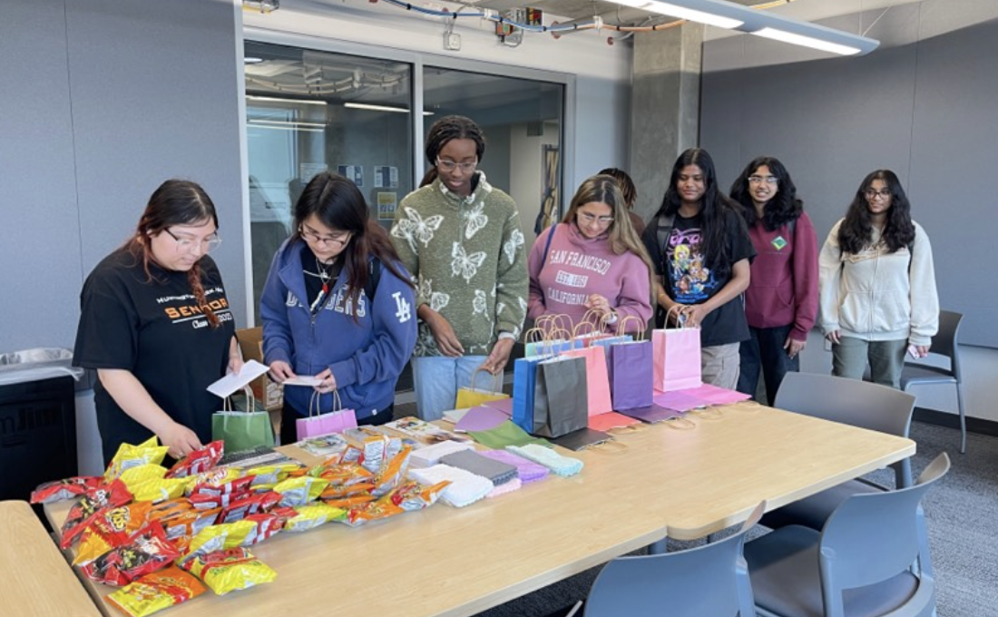 Students waiting in line to selected goodies to put together a self care bag for a womyn in their lives.